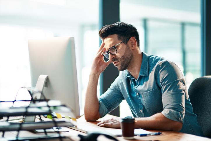 person sitting at computer looking worried